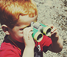 Young boy looking through binoculars